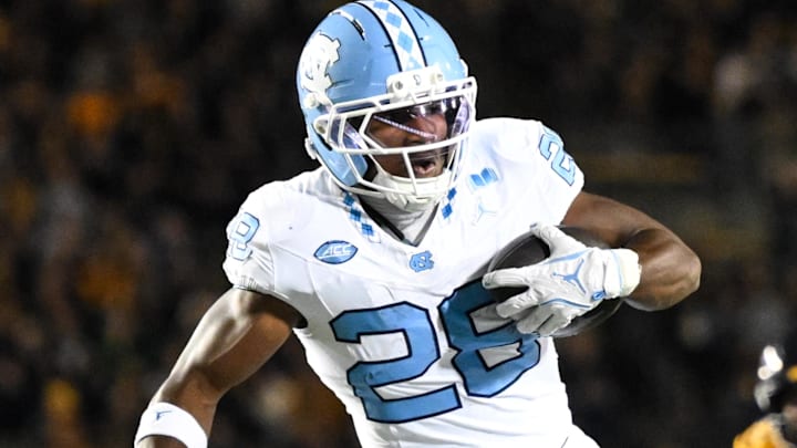 Oct 17, 2025; Berkeley, California, USA; North Carolina Tar Heels running back Benjamin Hall (28) evades tackle by California Golden Bears defensive back Aiden Manutai (14) before running for a touchdown in the first quarter at California Memorial Stadium. Mandatory Credit: Eakin Howard-Imagn Images