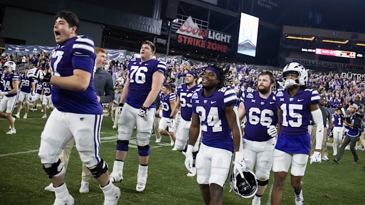 Dec 26, 2024; Phoenix, AZ, USA; Kansas State Wildcats offensive lineman Logan Cox (67) celebrates with running back JB Price (24) and wide receiver Trae Davis (15) after defeating the Rutgers Scarlet Knights during the Rate Bowl at Chase Field. Mandatory Credit: Mark J. Rebilas-Imagn Images