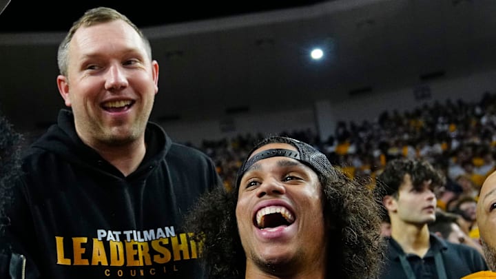 Arizona State football coach Kenny Dillingham (center) talks with former Arizona State guard James Harden (L) and wide receiver Jordyn Tyson during a game at Desert Financial Arena in Tempe, Ariz. on Jan. 31, 2026.