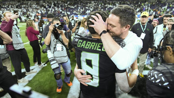 Oregon Ducks head coach Dan Lanning hugs quarterback Dillon Gabriel (8) 