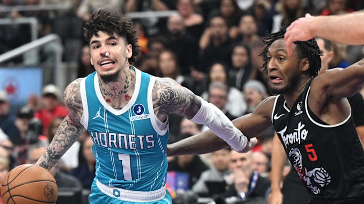 Charlotte Hornets guard LaMelo Ball dribbles the ball past Toronto Raptors guard Immanuel Quickley.