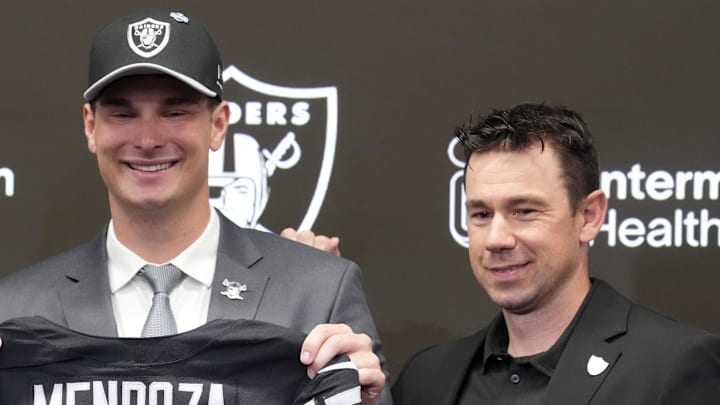 Apr 24, 2026; Henderson, NV, USA; Las Vegas Raiders quarterback Fernando Mendoza (center) poses with a jersey at an introductory press conference at Intermountain Health Performance Center, flanked by general manager John Spytek (left) and head coach Klint Kubiak after being selected as the No. 1 pick in the 2026 NFL Draft. Mandatory Credit: Kirby Lee-Imagn Images