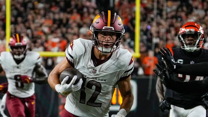 Washington Commanders wide receiver Luke McCaffrey (12) picks up yards around Cincinnati Bengals safety Geno Stone (22) Monday, September 23, 2024 at Paycor Stadium.