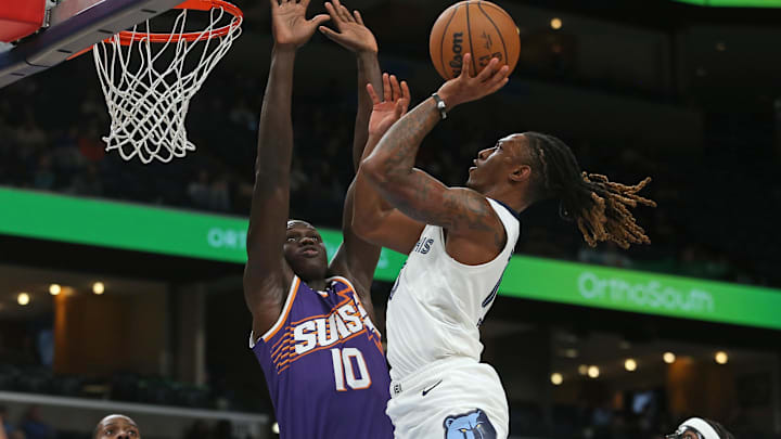Jan 7, 2026; Memphis, Tennessee, USA; Memphis Grizzlies guard Javon Small (10) drives to the basket as Phoenix Suns center Khaman Maluach (10) defends during the fourth quarter at FedExForum. Mandatory Credit: Petre Thomas-Imagn Images