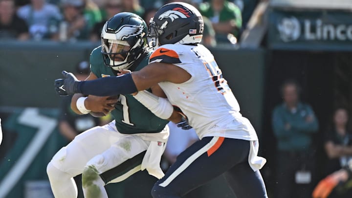 Oct 5, 2025; Philadelphia, Pennsylvania, USA; Philadelphia Eagles quarterback Jalen Hurts (1) is sacked by Denver Broncos linebacker Nik Bonitto (15) at Lincoln Financial Field. 