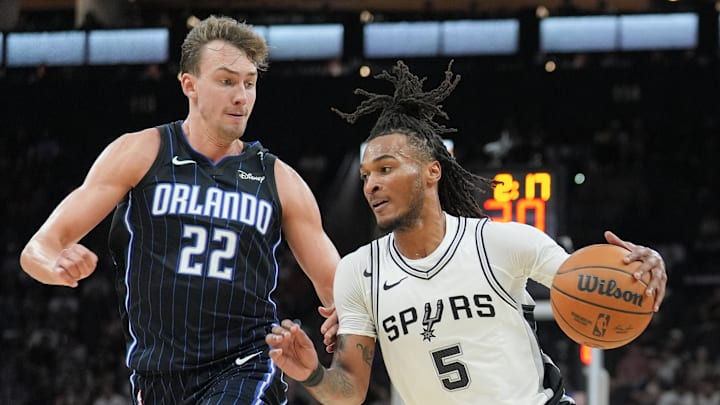 Oct 9, 2024; San Antonio, Texas, USA; San Antonio Spurs guard Stephon Castle (5) dribbles against Orlando Magic forward Franz Wagner (22) in the first half at Frost Bank Center. Mandatory Credit: