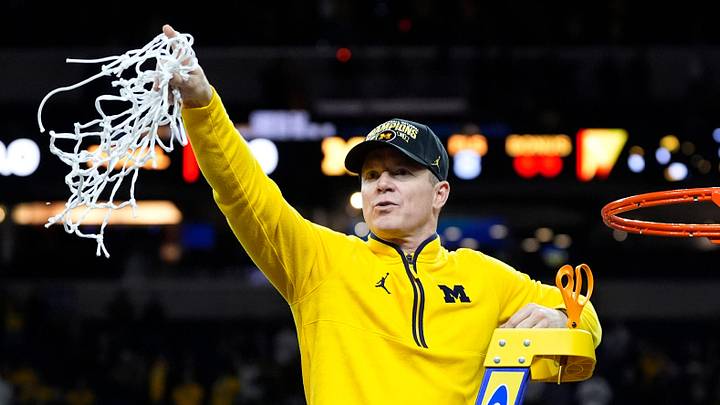 Michigan head coach Dusty May swings the net after winning the NCAA national championship against Connecticut at Lucas Oil Stadium in Indianapolis on Monday, April 6, 2026.