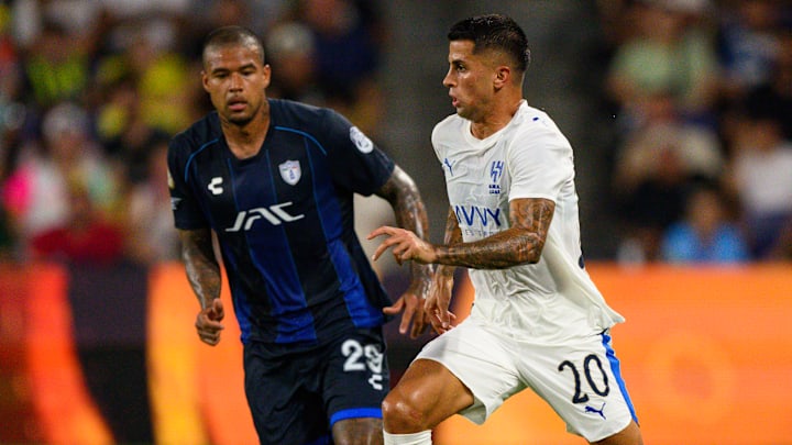 El portugués João Cancelo conduce el esférico ante la presión del venezolano Salomón Rondón