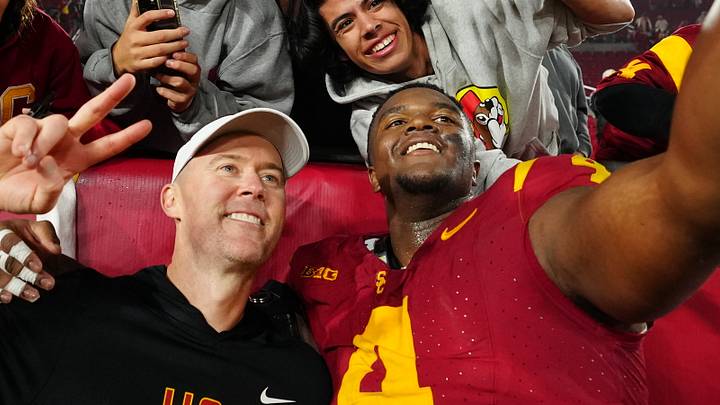 Nov 29, 2025; Los Angeles, California, USA; Southern California Trojans head coach Lincoln Riley (right) and defensive tackle Jahkeem Stewart (4) pose with fans after the game against the UCLA Bruins at United Airlines Field at Los Angeles Memorial Coliseum. 