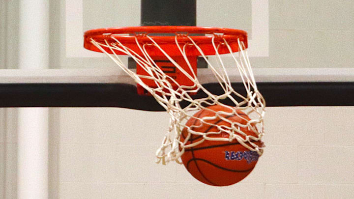 A basketball swishes the net as it goes through the hoop.