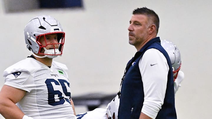 Jun 10, 2025; Foxborough, MA, USA; New England Patriots head coach Mike Vrabel (center) and offensive coordinator Josh McDaniels (r) work with center Garrett Bradbury (65), offensive tackle Mike Onwenu (71) and offensive tackle Morgan Moses (76) during minicamp held in the WIN Field House at Gillette Stadium. Mandatory Credit: Eric Canha-Imagn Images
