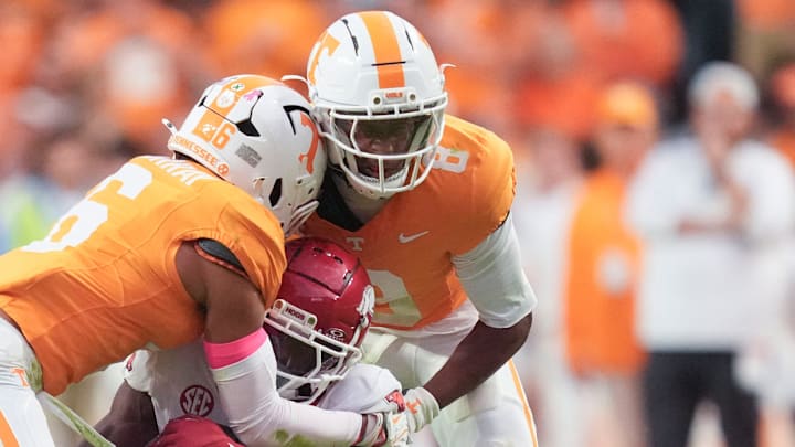 Tennessee defensive back Jalen McMurray (6) and Tennessee defensive back Colton Hood (8) tackle Arkansas wide receiver O’Mega Blake (9) during a college football game between Tennessee and Arkansas at Neyland Stadium in Knoxville, Tennessee on Oct. 11, 2025.