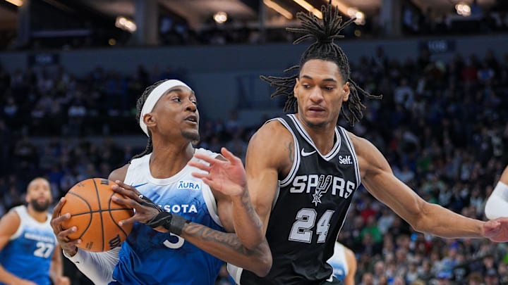Feb 27, 2024; Minneapolis, Minnesota, USA; Minnesota Timberwolves forward Jaden McDaniels (3) dribbles against the San Antonio Spurs guard Devin Vassell (24) in the first quarter at Target Center.