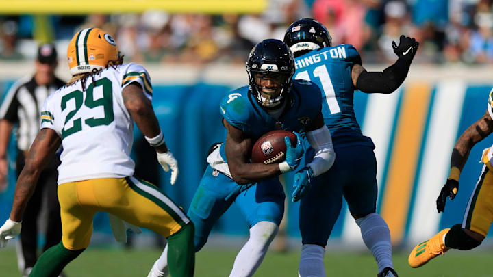 Jacksonville Jaguars running back Tank Bigsby (4) rushes for yards against Green Bay Packers safety Xavier McKinney (29) during the fourth quarter of an NFL football matchup Sunday, Oct. 27, 2024 at EverBank Stadium in Jacksonville, Fla. The Packers edged the Jaguars 30-27 on a last-second field goal. [Corey Perrine/Florida Times-Union]