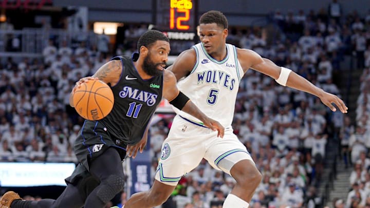 May 24, 2024; Minneapolis, Minnesota, USA; Dallas Mavericks guard Kyrie Irving (11) controls the ball against Minnesota Timberwolves guard Anthony Edwards (5) in the third quarter during game two of the western conference finals for the 2024 NBA playoffs at Target Center. Mandatory Credit: Brad Rempel-Imagn Images