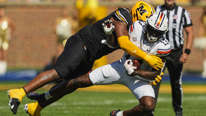 Oct 19, 2024; Columbia, Missouri, USA; Auburn Tigers tight end Rivaldo Fairweather (13) is tackled by Missouri Tigers defensive tackle Chris McClellan (7) during the first half at Faurot Field at Memorial Stadium. Mandatory Credit: Jay Biggerstaff-Imagn Images