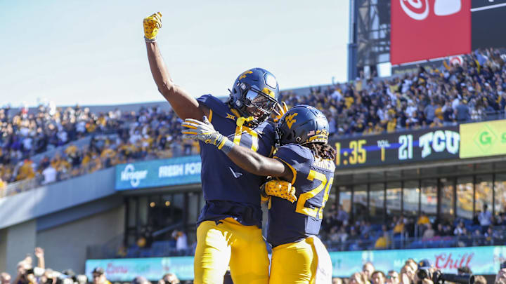 Oct 29, 2022; Morgantown, West Virginia, USA; West Virginia Mountaineers running back Justin Johnson Jr. (26) scores a touchdown and celebrates with West Virginia Mountaineers wide receiver Bryce Ford-Wheaton (0) during the second quarter against the TCU Horned Frogs at Mountaineer Field at Milan Puskar Stadium. Oct 29, 2022; Morgantown, West Virginia, USA; West Virginia Mountaineers running back Justin Johnson Jr. (26) scores a touchdown and celebrates with West Virginia Mountaineers wide receiver Bryce Ford-Wheaton (0) during the second quarter against the TCU Horned Frogs at Mountaineer Field at Milan Puskar Stadium.