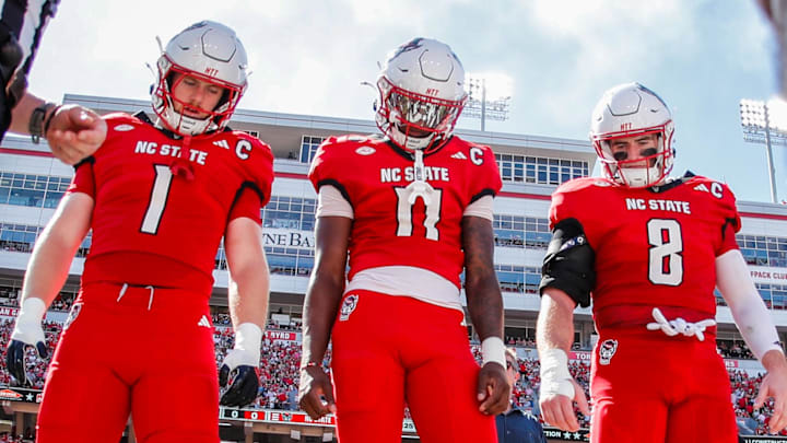 Oct 4, 2025; Raleigh, North Carolina, USA; NC State Wolfpack quarterback CJ Bailey (11), linebacker Caden Fordham (1), wide receiver Keenan Jackson (8) during the coin toss prior to the first half of the game against Campbell Fighting Camels at Carter-Finley Stadium. Mandatory Credit: Jaylynn Nash-Imagn Images