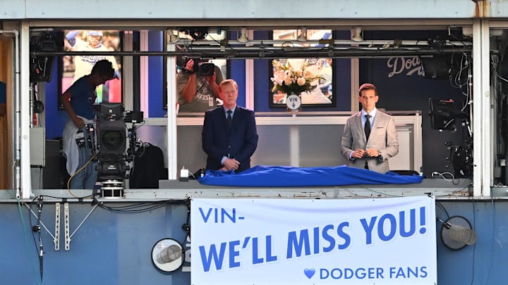 Dodgers broadcasters Orel Hersheiser and Joe Davis unveil a banner in honor of Vin Scully during a ceremony prior to the game against the San Diego Padres at Dodger Stadium. The Hall of Famer passed away this week at the age of 94. 