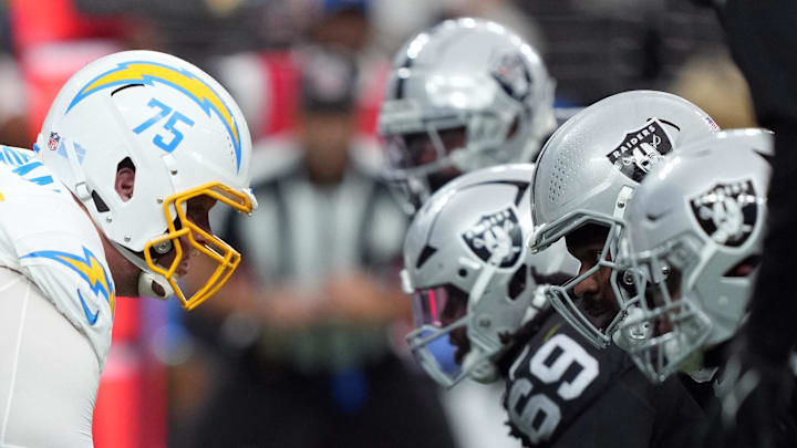 Jan 5, 2025; Paradise, Nevada, USA; Helmets of Los Angeles Chargers center Bradley Bozeman (75) snaps the ball against the Las Vegas Raiders in the first half at Allegiant Stadium. Mandatory Credit: Kirby Lee-Imagn Images
