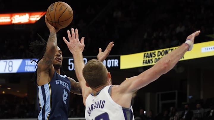 Jan 1, 2023; Memphis, Tennessee, USA; Memphis Grizzlies guard Ja Morant (12) shoots as Sacramento Kings forward Domantas Sabonis (10) defends during the second half at FedExForum. Mandatory Credit: Petre Thomas-Imagn Images