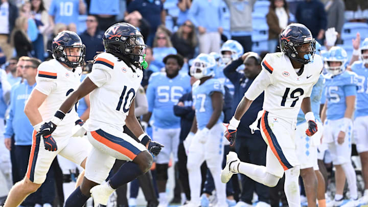 Oct 25, 2025; Chapel Hill, North Carolina, USA;  Virginia Cavaliers players celebrate after stopping North Carolina Tar Heels short of the goal line on a two point try to win in overtime at Kenan Stadium. Mandatory Credit: Bob Donnan-Imagn Images