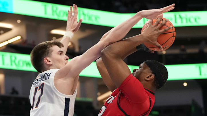 Mar 12, 2026; Charlotte, NC, USA; NC State Wolfpack forward Ven-Allen Lubin (22) shoots as Virginia Cavaliers center Johann Grünloh (17) defends in the first half at Spectrum Center. Mandatory Credit: Bob Donnan-Imagn Images