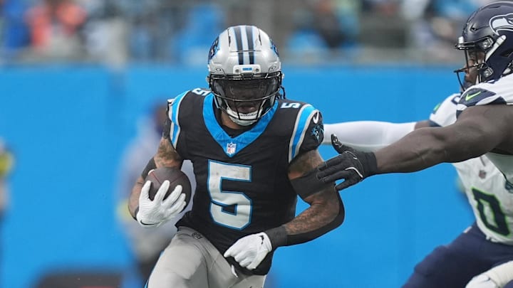 Dec 28, 2025; Charlotte, North Carolina, USA; Carolina Panthers running back Rico Dowdle (5) runs the ball against Seattle Seahawks defensive tackle Jarran Reed (90) during the third quarter at Bank of America Stadium. Mandatory Credit: Jim Dedmon-Imagn Images