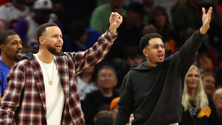 Feb 5, 2026; Phoenix, Arizona, USA; Golden State Warriors guard Stephen Curry (left) and brother Seth Curry react against the Phoenix Suns in the second half at Mortgage Matchup Center. Mandatory Credit: Mark J. Rebilas-Imagn Images