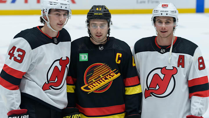 Brothers Luke (left), Quinn (center), and Jack (right) Hughes pose for a photo before a contest between the New Jersey Devils and Vancouver Canucks.