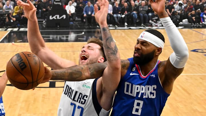 Jan 10, 2023; Los Angeles, California, USA; Dallas Mavericks guard Luka Doncic (77) and Los Angeles Clippers forward Marcus Morris Sr. (8) battle for a rebound in the first half at Crypto.com Arena. Mandatory Credit: Jayne Kamin-Oncea-Imagn Images