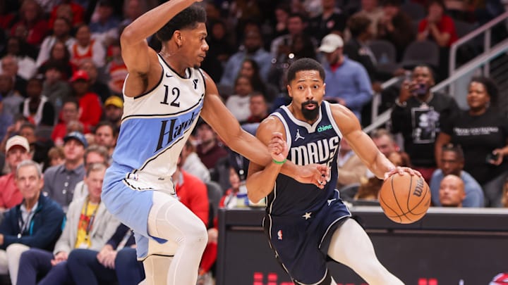 Nov 25, 2024; Atlanta, Georgia, USA; Dallas Mavericks guard Spencer Dinwiddie (26) drives on Atlanta Hawks forward De'Andre Hunter (12) in the second quarter at State Farm Arena. Mandatory Credit: Brett Davis-Imagn Images