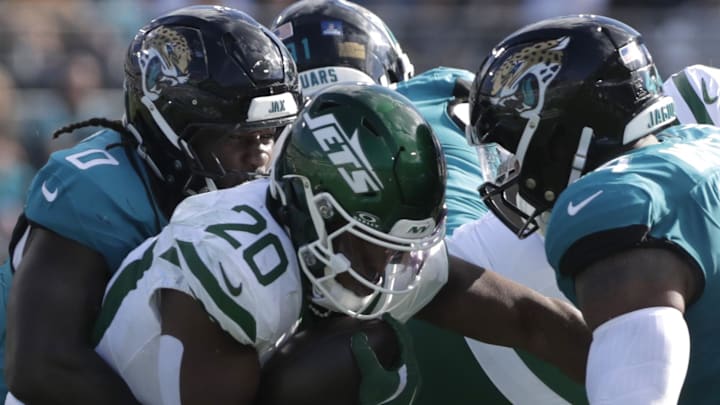 Dec 14, 2025; Jacksonville, Florida, USA; Jacksonville Jaguars linebacker Devin Lloyd (0) tackles New York Jets running back Breece Hall (20) as he carries the ball during the second quarter at EverBank Stadium. Mandatory Credit: Travis Register-Imagn Images