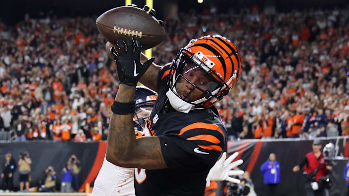 Dec 28, 2024; Cincinnati, Ohio, USA;  Cincinnati Bengals  wide receiver Tee Higgins (5) catches a touchdown as Denver Broncos cornerback Riley Moss (21) defends during the fourth quarter at Paycor Stadium. Mandatory Credit: Joseph Maiorana-Imagn Images
