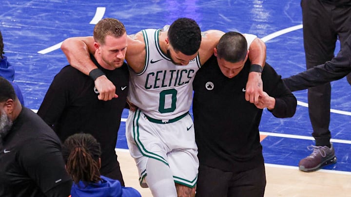 May 12, 2025; New York, New York, USA; Boston Celtics forward Jayson Tatum (0) is helped off the court by after an injury in the second half during game four of the second round for the 2025 NBA Playoffs against the New York Knicks at Madison Square Garden. Tatum would leave the game with an injury after this play. Mandatory Credit: Vincent Carchietta-Imagn Images