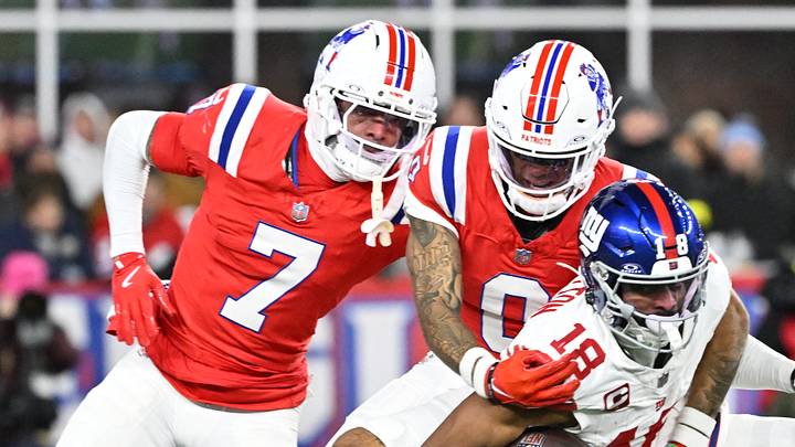 Dec 1, 2025; Foxborough, Massachusetts, USA; New York Giants wide receiver Darius Slayton (18) runs after a catch for a touchdown against New England Patriots cornerback Christian Gonzalez (0) and New England Patriots cornerback Carlton Davis III (7) during the second quarter at Gillette Stadium. Mandatory Credit: Eric Canha-Imagn Images