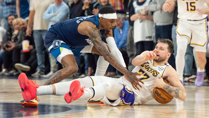 Apr 27, 2025; Minneapolis, Minnesota, USA; Los Angeles Lakers guard Luka Doncic (77) calls a timeout after stumbling on the defense of Minnesota Timberwolves forward Jaden McDaniels (3) in the fourth quarter during game four of first round for the 2025 NBA Playoffs at Target Center. Mandatory Credit: Matt Blewett-Imagn Images