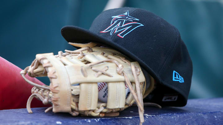 Apr 24, 2024; Atlanta, Georgia, USA; A detailed view of a Miami Marlins hat and glove in the dugout before a game against the Atlanta Braves at Truist Park. Mandatory Credit: Brett Davis-Imagn Images