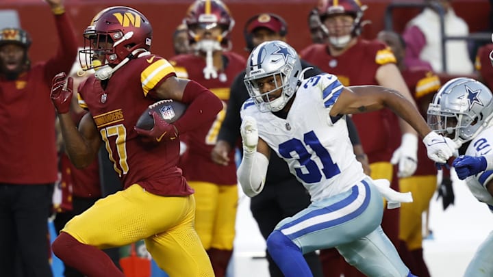 Washington Commanders wide receiver Terry McLaurin (17) runs with the ball en route to a touchdown as Dallas Cowboys cornerback Josh Butler (31) chases during the fourth quarter at Northwest Stadium.