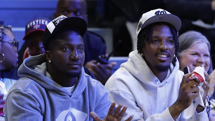 May 16, 2025; Washington, District of Columbia, USA; Washington Commanders wide receiver Deebo Samuels (L) and Commanders quarterback Jayden Daniels (R) wave to the crowd from courts wide during the game between the Washington Mystics and Atlanta Dream at CareFirst Arena. Mandatory Credit: Geoff Burke-Imagn Images May 16, 2025; Washington, District of Columbia, USA; Washington Commanders wide receiver Deebo Samuels (L) and Commanders quarterback Jayden Daniels (R) wave to the crowd from courts wide during the game between the Washington Mystics and Atlanta Dream at CareFirst Arena. Mandatory Credit: Geoff Burke-Imagn Images