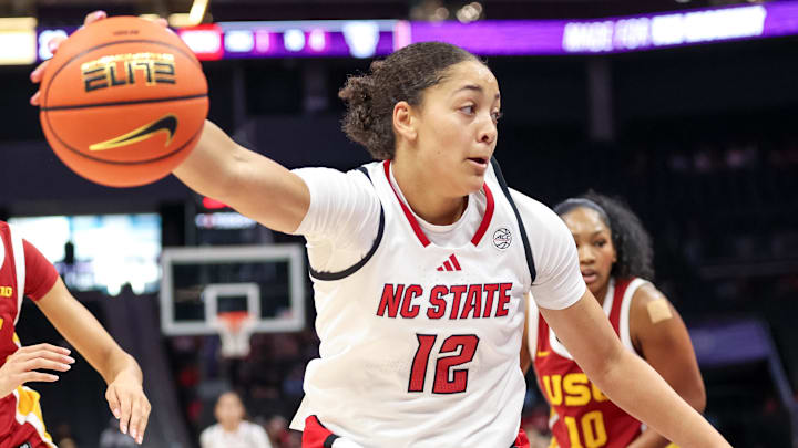 Nov 9, 2025; Charlotte, North Carolina, USA; NC State Wolfpack forward Khamil Pierre (12) controls the ball against the Southern California Trojans during the second quarter of the Ally Tipoff game at Spectrum Center. Mandatory Credit: Cory Knowlton-Imagn Images