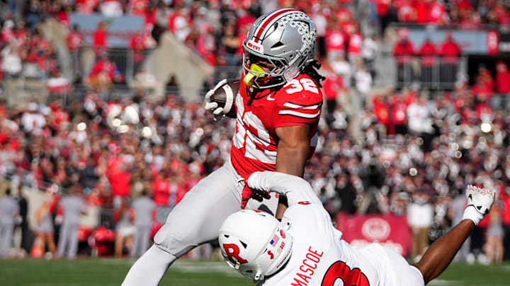 Ohio State Buckeyes running back Isaiah West (32) runs over Rutgers Scarlet Knights defensive back Bo Mascoe (3) during the NCAA football game at Ohio Stadium in Columbus on Nov. 22, 2025. Ohio State won 42-9.