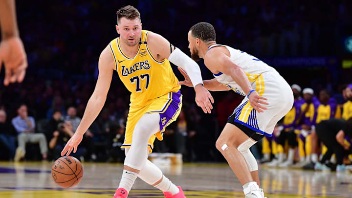 Apr 3, 2025; Los Angeles, California, USA; Los Angeles Lakers guard Luka Dončić (77) moves the ball against Golden State Warriors guard Stephen Curry (30) during the first half at Crypto.com Arena.