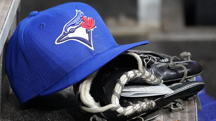 Apr 16, 2025; Toronto, Ontario, CAN; A Toronto Blue Jays hat and glove in the dugout during a game against the Atlanta Braves at Rogers Centre. 