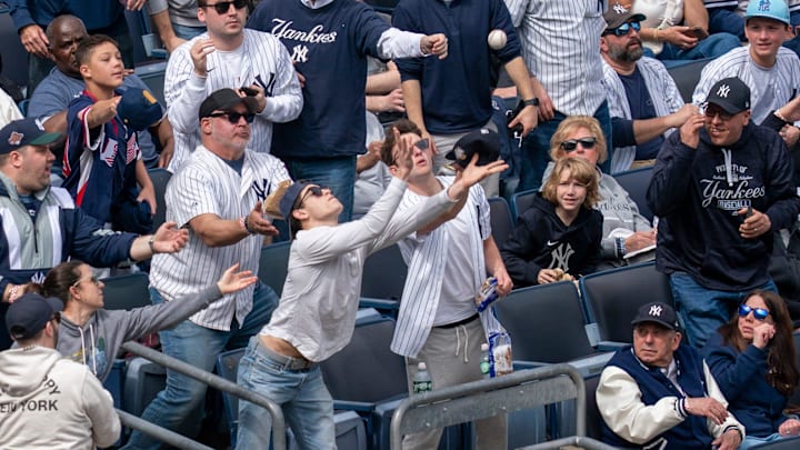 Fans attempt to catch a foul ball during the home opener baseball game between the New York Yankees and Miami Marlins at Yankee Stadium in Bronx, NY, Friday, April 3, 2026.