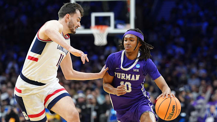 Furman Paladins guard Alex Wilkins (10) dribbles the ball past UConn Huskies forward Alex Karaban (11) in the first half during a first round game of the men's 2026 NCAA Tournament at Xfinity Mobile Arena.