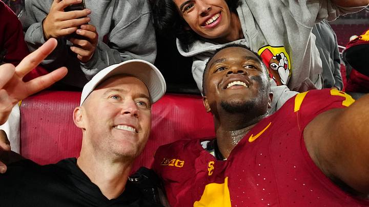 Nov 29, 2025; Los Angeles, California, USA; Southern California Trojans head coach Lincoln Riley (right) and defensive tackle Jahkeem Stewart (4) pose with fans after the game against the UCLA Bruins at United Airlines Field at Los Angeles Memorial Coliseum. 