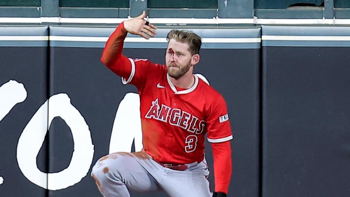 Los Angeles Angels left fielder Taylor Ward (3) calls for the trainer after sustaining an injury while attempting to field a ball hit by Houston Astros second baseman Ramon Urias (29, not shown) during the eighth inning at Daikin Park. 