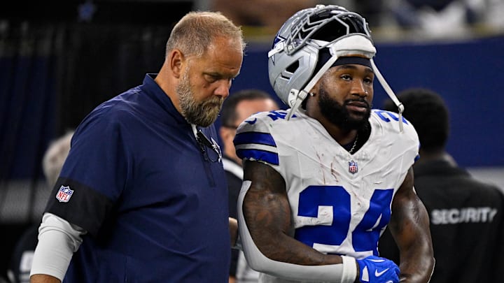 Dallas Cowboys running back Miles Sanders (24) walks off the field with team staff during the game between the Dallas Cowboys and the Green Bay Packers at AT&T Stadium.