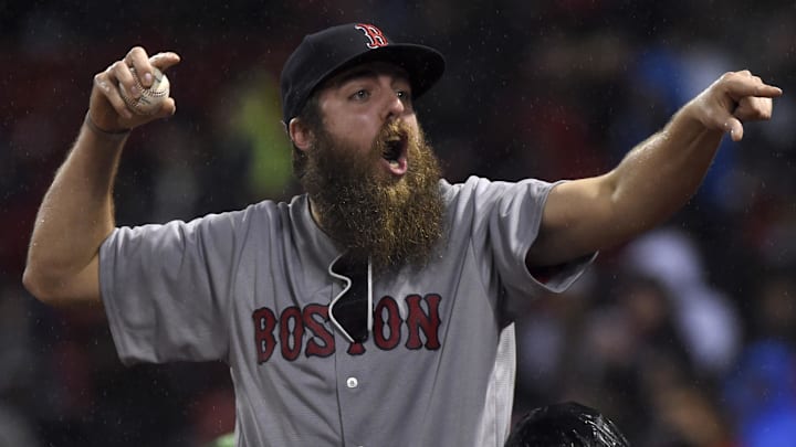 A fan reacts after getting a ball during the sixth inning in a game against the Boston Red Sox and Seattle Mariners at Fenway Park.